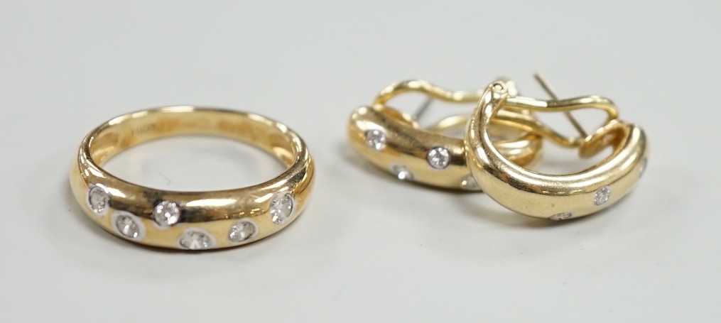 A modern 14k and gypsy set six stone diamond band, size N and a pair of matching earrings, gross weight 8.1 grams.